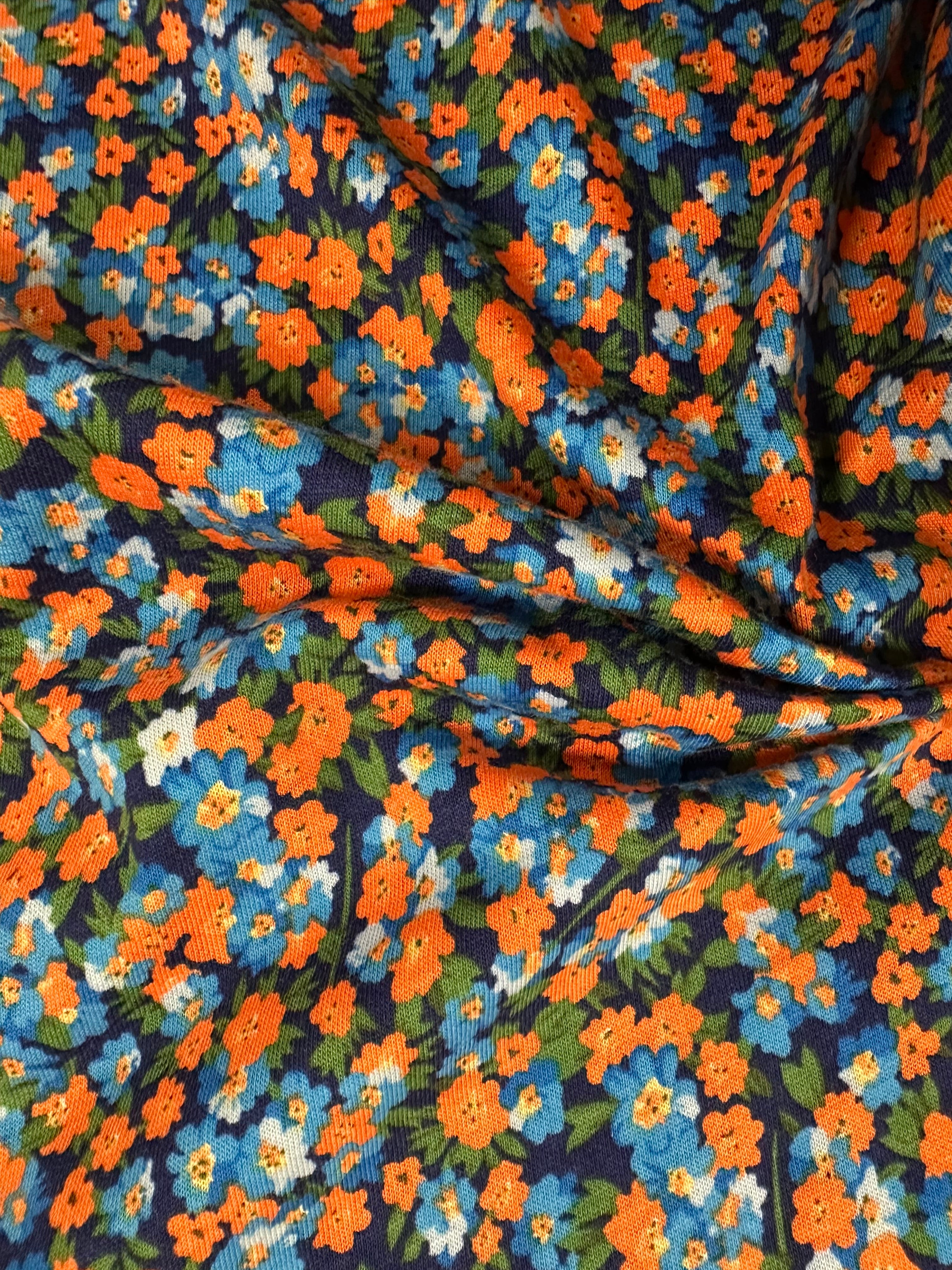 Shop stretch cotton fabric, 178 cm wide, 97% cotton, 3% elastane. Navy base with contemporary flowers in orange, blue, green & white