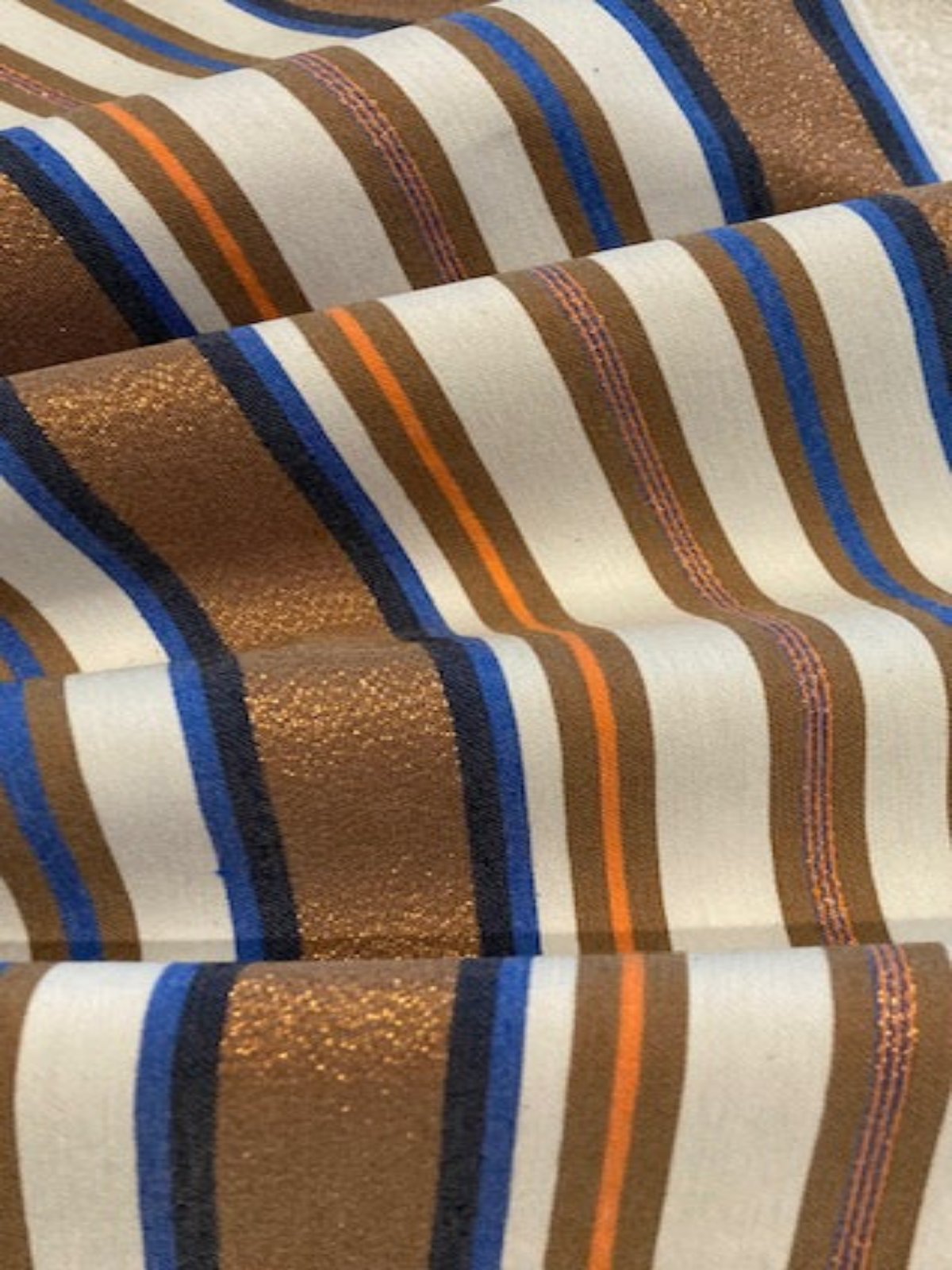 Bronze & Blue Woven Stripe with Lurex Detail. One Way Stretch. Stripes run across the fabric.