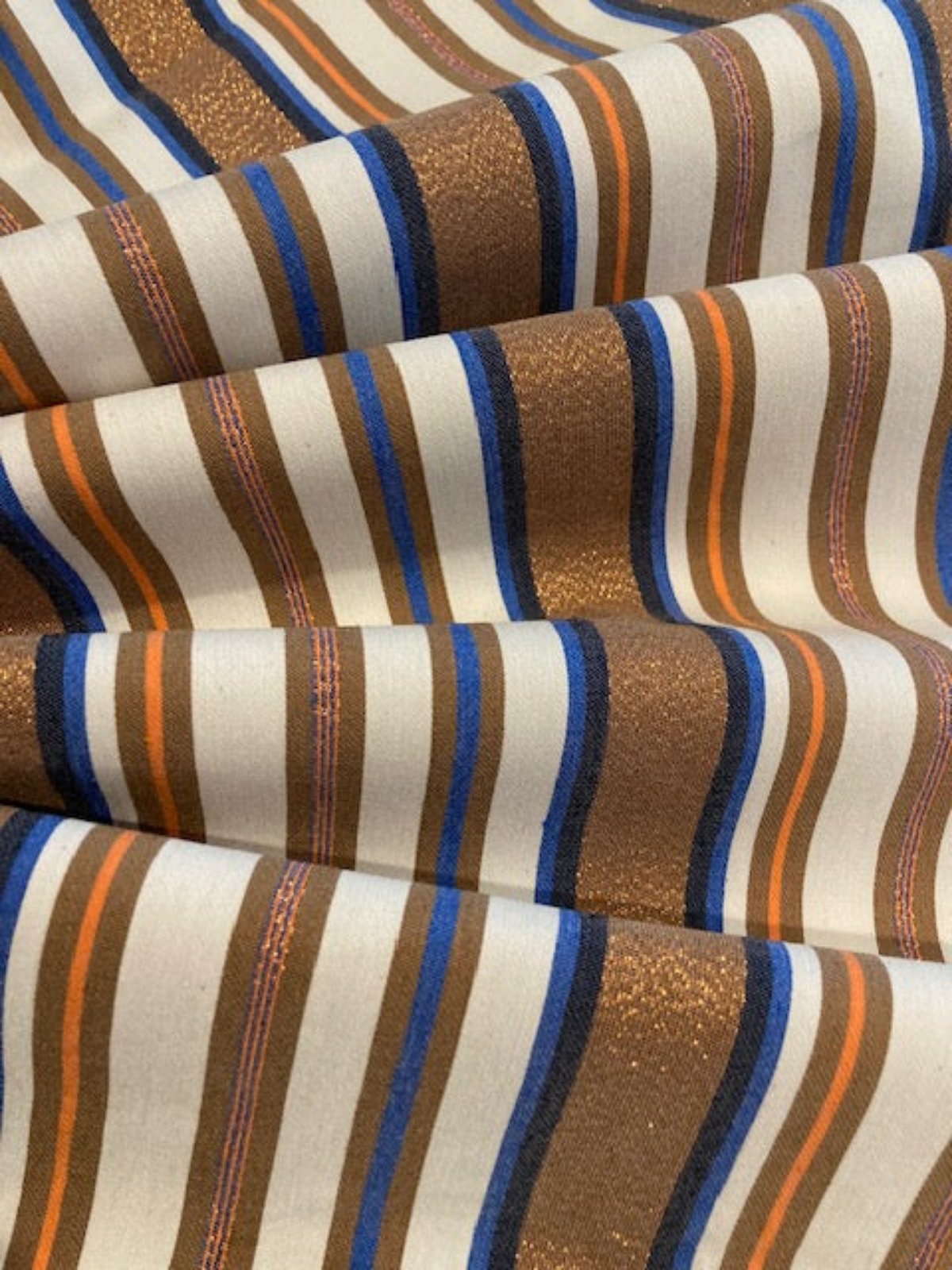 Bronze & Blue Woven Stripe with Lurex Detail. One Way Stretch. Stripes run across the fabric.