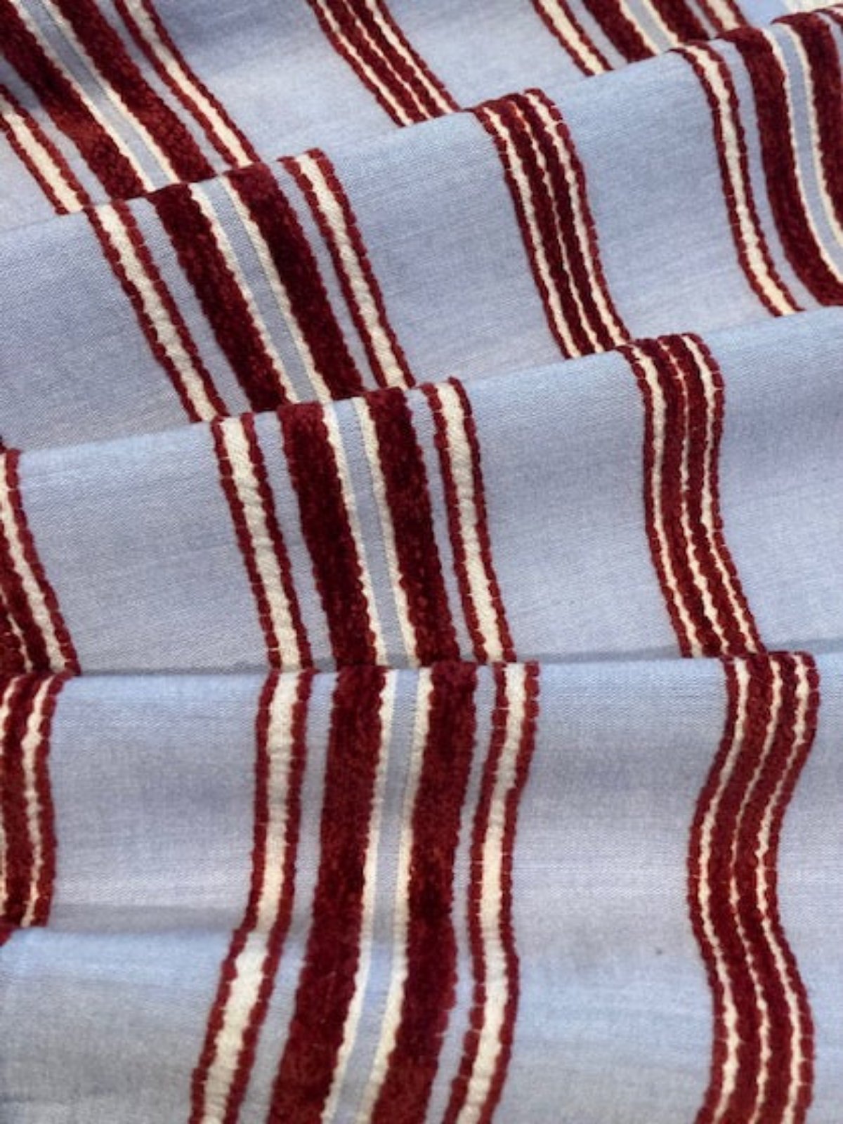 Red Raised Stripe on Sky Blue. Soft Handle, Stripes run across the fabric.