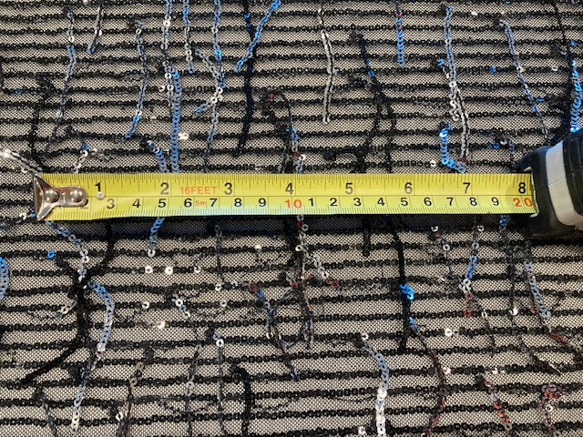 Silver Sequin Tassel on Black Stretch Tulle. Tassels run across the piece.