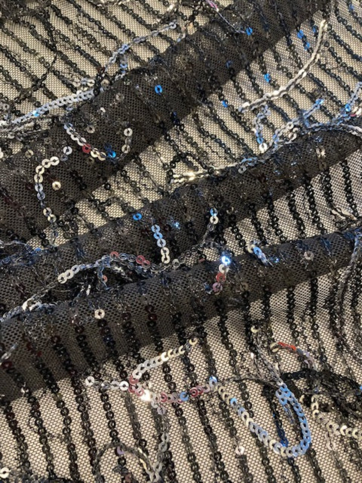 Silver Sequin Tassel on Black Stretch Tulle. Tassels run across the piece.