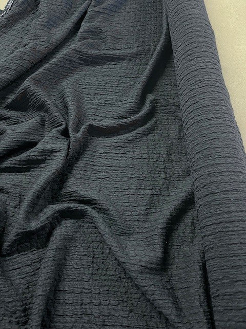 Black Textured Seersucker. 170g/m2, 98% Polyester 2% Elastane. Roll Size: 1.7m