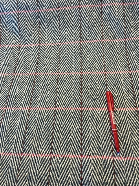 Blue Herringbone Wool Mix With Cerise Detail. 20% Wool 80% Mixed Fibres. 450g/m2, 145cm Wide. Roll Size: 2.3m