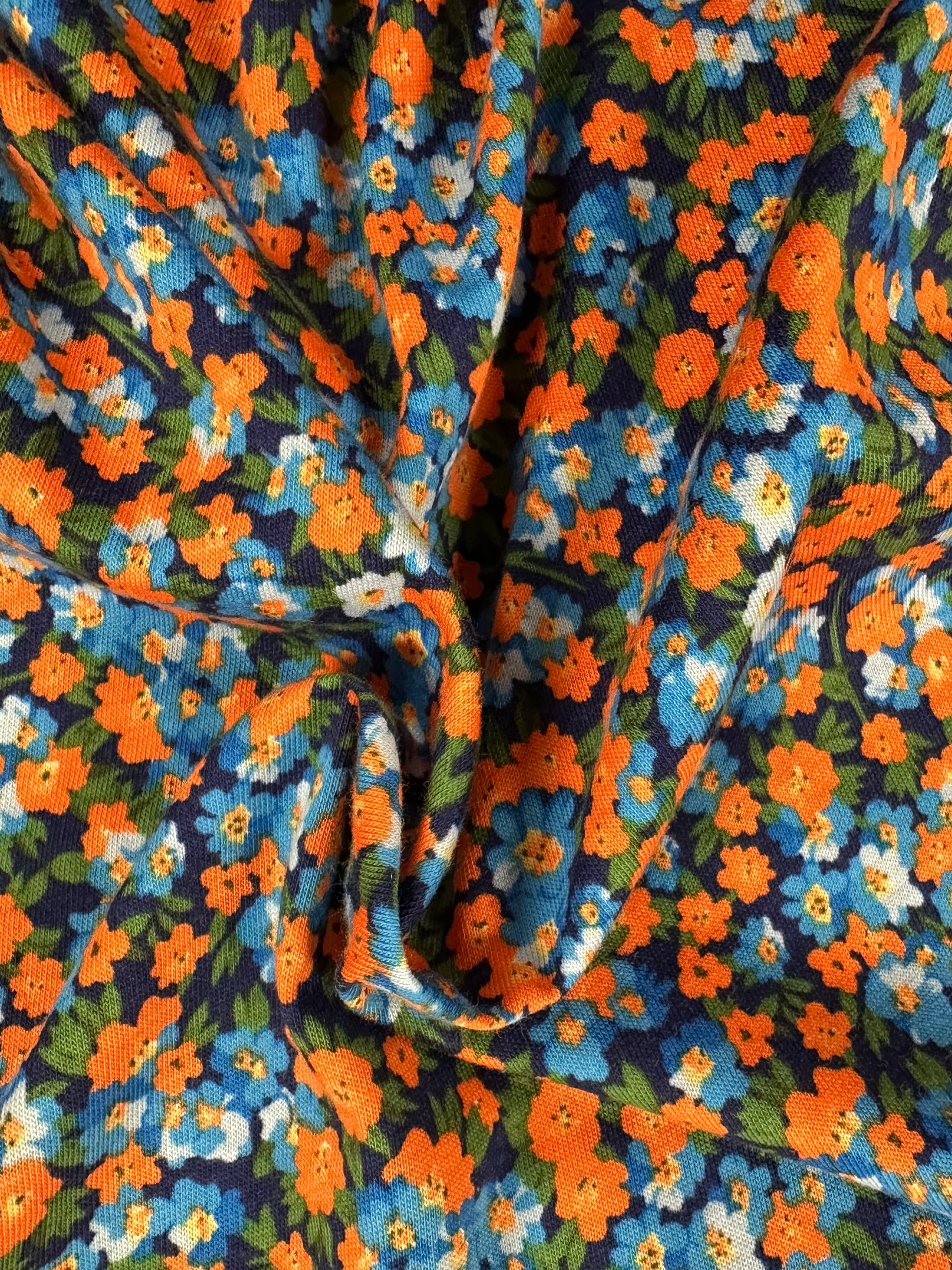 Shop stretch cotton fabric, 178 cm wide, 97% cotton, 3% elastane. Navy base with contemporary flowers in orange, blue, green & white