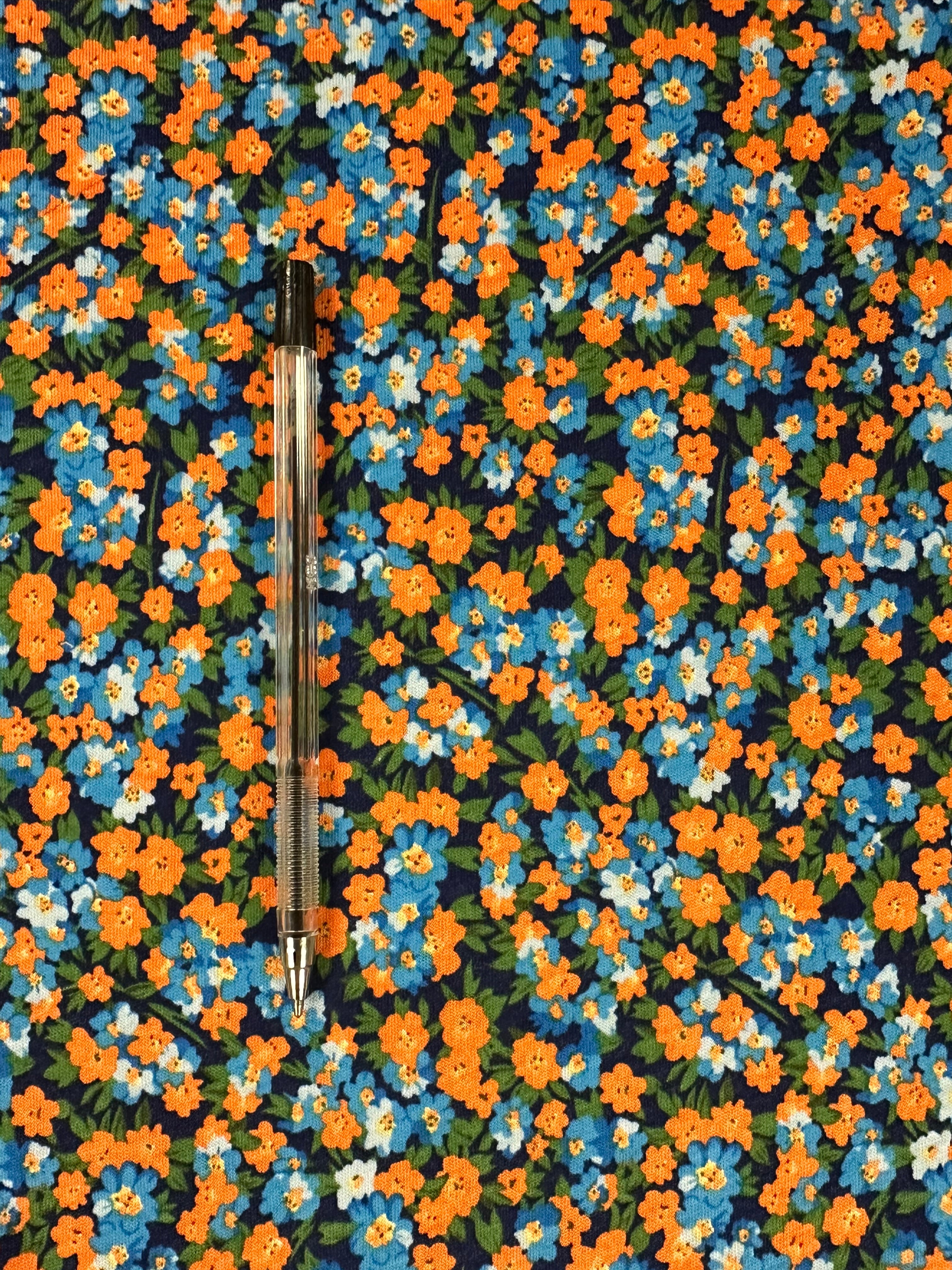 Shop stretch cotton fabric, 178 cm wide, 97% cotton, 3% elastane. Navy base with contemporary flowers in orange, blue, green & white