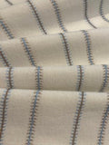 Blue/Burnt Orange Woven Fish Bone Stripe on Ivory. Stripes run across the Fabric.