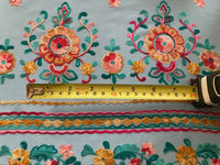 Teal/Gold/Red Embroidery on Sky Blue. Embroidery Runs Along Each Edge of Fabric as a Border