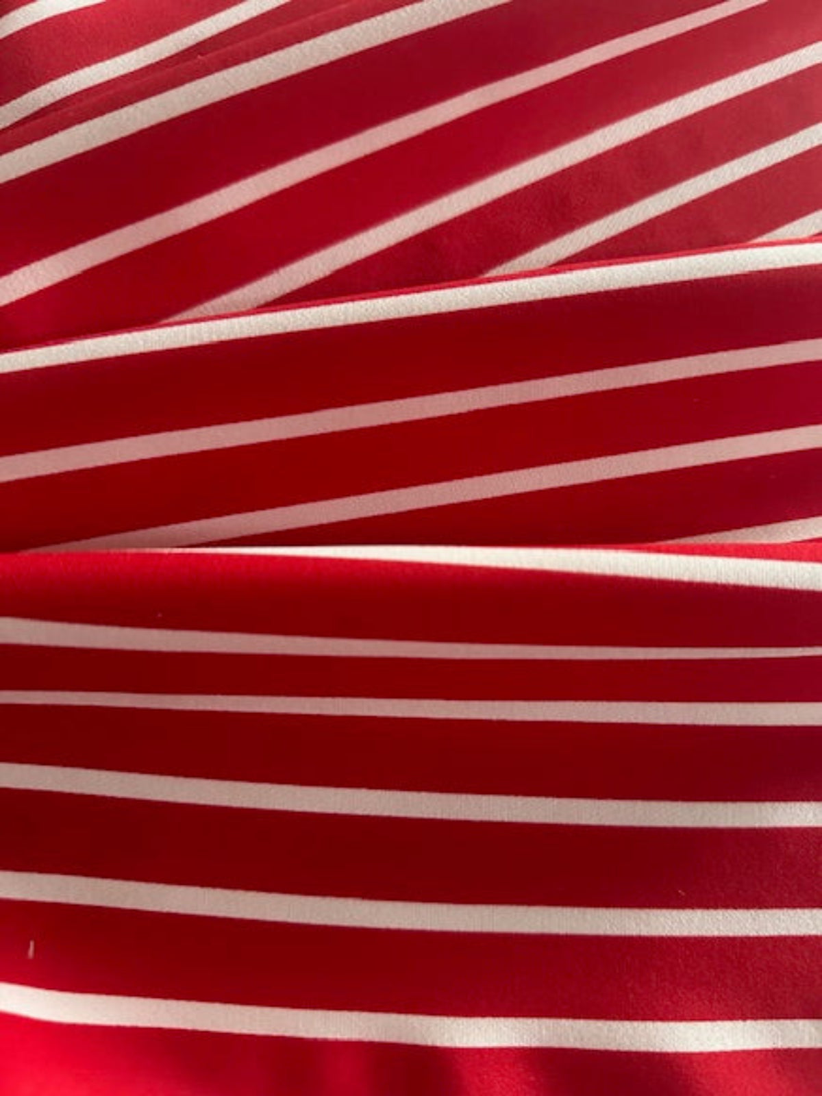 Red Butcher Stripe with stretch. Stripes run along the Fabric.