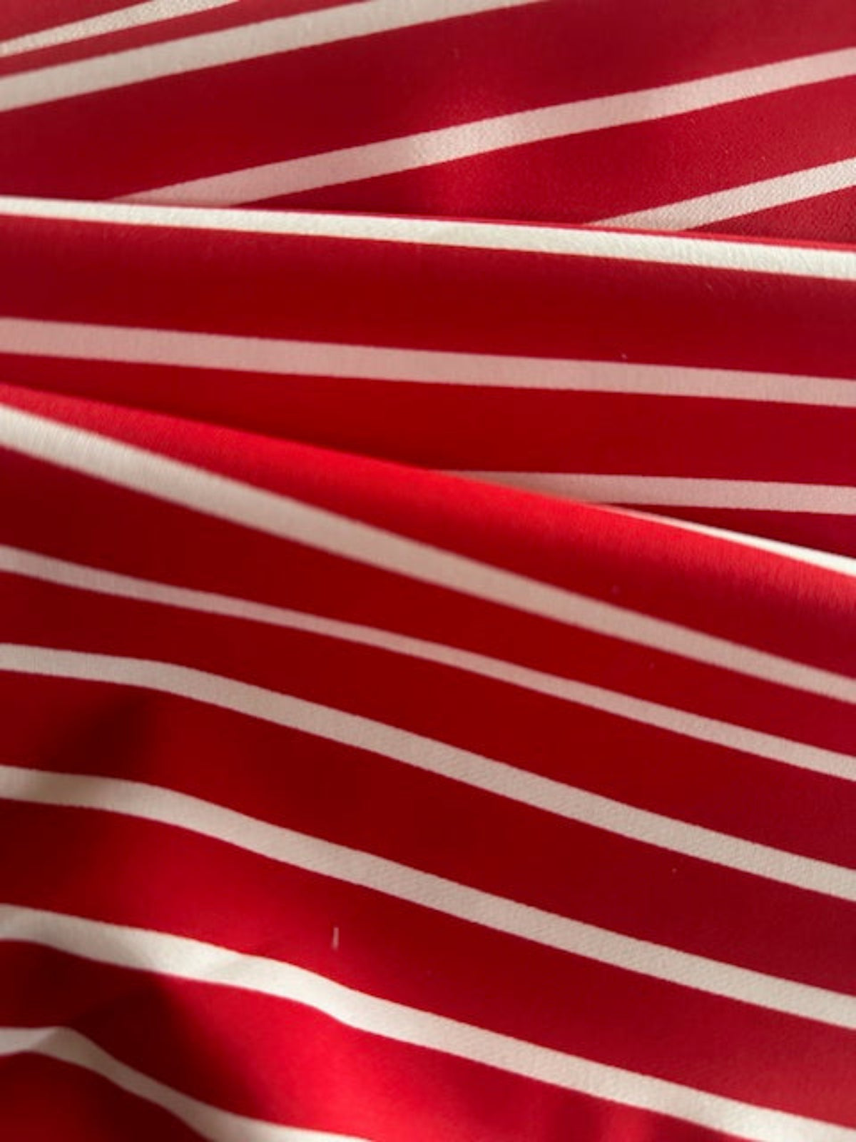 Red Butcher Stripe with stretch. Stripes run along the Fabric.