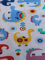 Multi coloured Dinosaurs on pale Pink Cotton Sateen - Deadstock fabric on AmoThreads